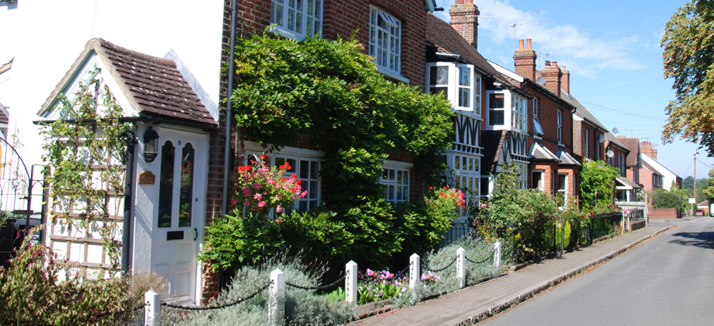 Traditional brick houses and greenery on a quiet residential street in Hildenborough near the MOT centre.