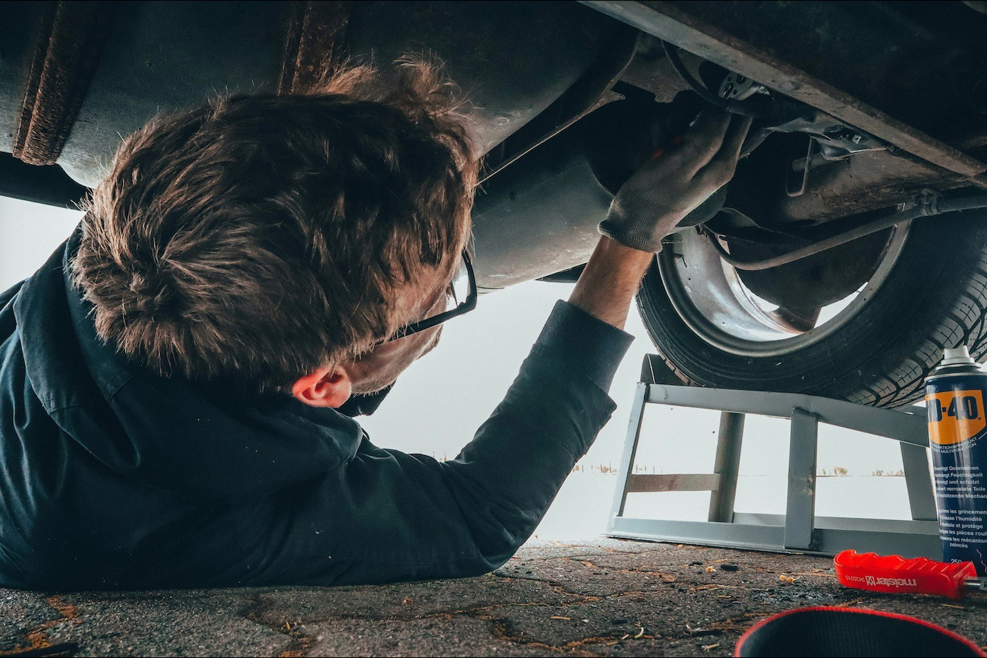Certified MOT tester inspecting the underside of a vehicle in Hildenborough