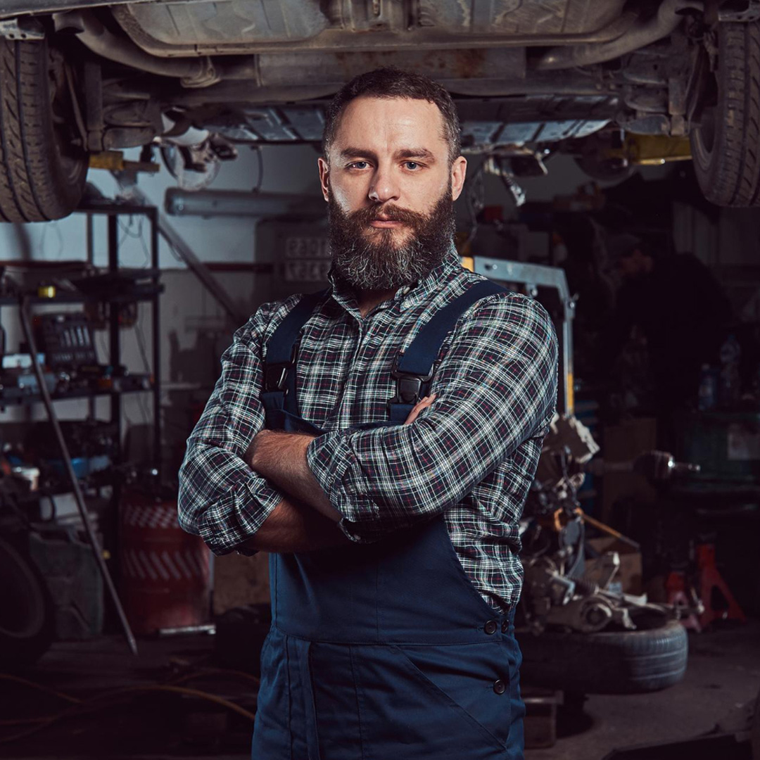 Portrait of Sam Stillman, founder of Hildenborough MOT Test Centre, standing in a professional workshop.