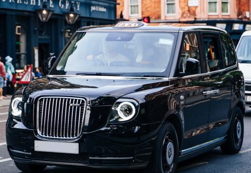 Black taxi cab parked on a street, representing cost-effective compliance testing for independent taxi drivers.